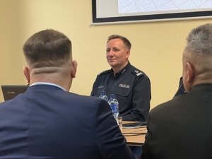 na zdjęciu komendant wśród gości siedzący przed stolikiem