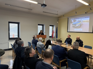 na zdjęciu goście, policjanci i osoba przy mównicy