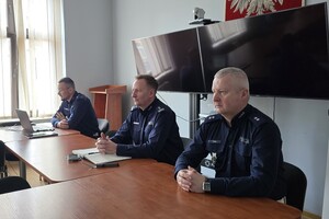 na zdjęciu policjanci siedzący za stołem