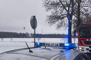Na zdjęciu policyjny radiowóz fragment wozu strażackiego i lądujący śmigłowiec lotniczego Pogotowia Ratunkowego