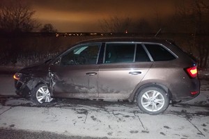 na zdjęciu samochód osobowy na jezdni z uszkodzeniami po zmroku