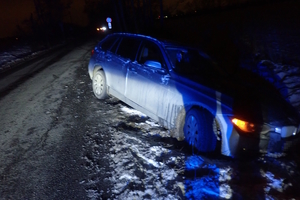 na zdjęciu samochód osobowy częściowo na jezdni i w rowie po zmroku