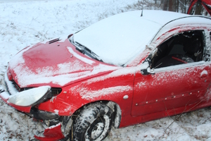 na zdjęciu czerwony samochód w rowie
