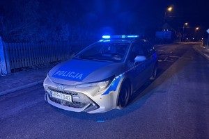 na zdjęciu radiowóz policyjny na sygnałach na jezdni po zmroku