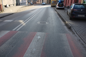 na zdjęciu odcinek drogi, na którym przejście dla pieszych a obok pojazd, radiowóz i karetka