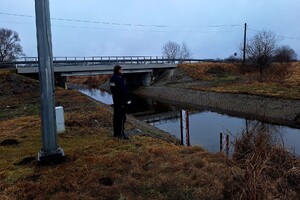 na zdjęciu policjant przy korycie rzeki