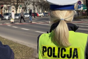 na zdjęciu policjant tyłem na ulicy