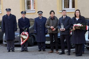 na zdjęciu przedstawiciele służb z kwiatami i inne osoby