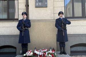 na zdjęciu policjanci pełniący wartę honorową pod pamiątkową tablicą, pod którą leżą wiązanki kwiatów