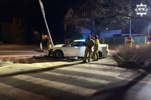 na zdjęciu samochód przy ulicznej latarni obok strażacy