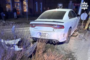 na zdjęciu samochód przy ulicznej latarni obok strażacy