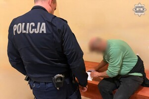 na zdjęciu policjant, a obok na ławce zatrzymany mężczyzna