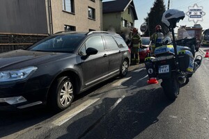 na zdjęciu policyjny motocykl przy samochodzie, gdzie obok stoją strażacy
