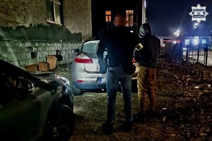 na zdjęciu policjant z zatrzymanym przy pojeździe