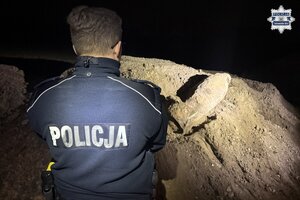 na zdjęciu policjant przed bomba leżącą na hałdzie ziemi