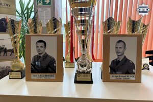 na zdjęciu pamiątkowe zdjęcia żołnierzy obok pucharów
