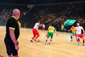 na zdjęciu policjant sędzia i grający na parkiecie piłkarze