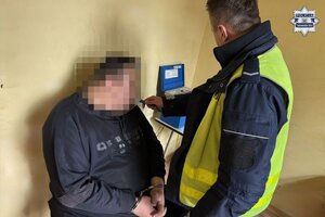 na zdjęciu policjant z zatrzymanym w trakcie badania alkomatem