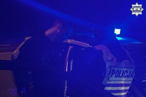 na zdjęciu policjant i mężczyzna przy radiowozie