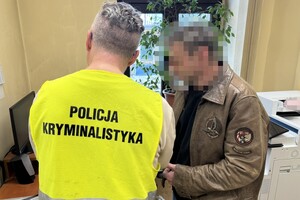 na zdjęciu policjant w kamizelce z napisem technik kryminalistyki, a obok niego zatrzymany mężczyzna
