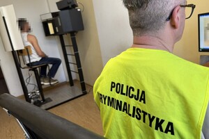 na zdjęciu policjant w kamizelce z napisem technik kryminalistyki, a obok niego zatrzymany mężczyzna