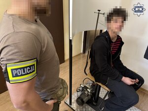 na zdjęciu policjant obok zatrzymanego, który siedzi na krześle