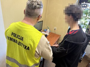 na zdjęciu policjant z kamizelką policja kryminalistyka, obok mężczyzna