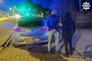 Na zdjęciu policjant z osobą zatrzymana przy pojeździe