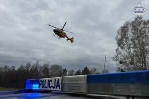 na zdjęciu policyjny neon a nad nim startujący śmigłowiec ratunkowy
