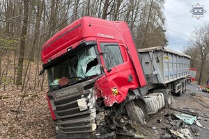na zdjęciu uszkodzony samochód ciężarowy wraz z naczepą częściowo na jezdni i w rowie