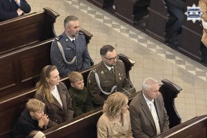 na zdjęciu w ławkach kościelnych ludzie i policjant