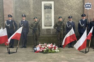 na zdjęciu policjanci, funkcjonariusze służby więziennej i żołnierze w trakcie warty honorowej po pamiątkową tablicą a przed nimi kwiaty