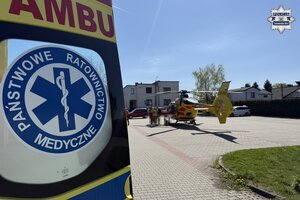 na zdjęciu fragment karetki pogotowia, a za nią śmigłowiec ratunkowy na parkingu