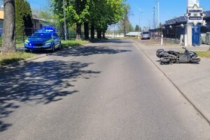 na zdjęciu leżący motocykl, a po drugiej stronie jedni radiowóz
