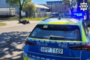 na zdjęciu leżący motocykl, a po drugiej stronie jedni radiowóz