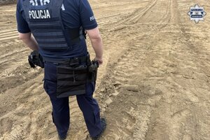 na zdjęciu policjant a przed nim pocisk