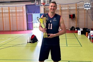 na zdjęciu dzielnicowy Kampa w stroju sportowym i pucharem w rękach