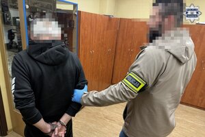 na zdjęciu policjant z zatrzymanym w pomieszczeniu