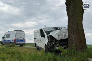 na zdjęciu samochód dostawczy wbity w drzewo, a za nim policyjny radiowóz