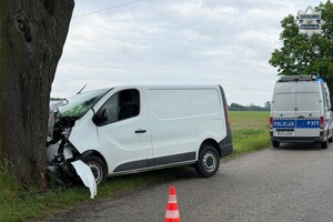 na zdjęciu samochód dostawczy wbity w drzewo, a za nim policyjny radiowóz