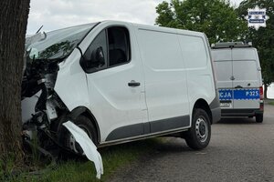 na zdjęciu samochód dostawczy wbity w drzewo, a za nim policyjny radiowóz