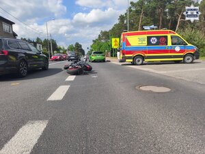 na zdjęciu policyjne radiowozy, samochody, karetka pogotowia i policjanci na skrzyżowaniu, gdzie na środku jezdni leży motocykl