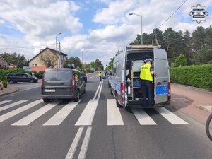 na zdjęciu policyjne radiowozy, samochody, karetka pogotowia i policjanci na skrzyżowaniu, gdzie na środku jezdni leży motocykl