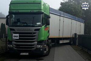 na zdjęciu samochód ciężarowy wraz z naczepą w wąskiej uliczce
