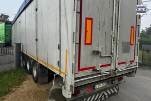 na zdjęciu samochód ciężarowy wraz z naczepą w wąskiej uliczce