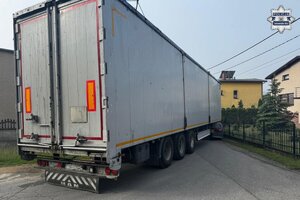 na zdjęciu samochód ciężarowy wraz z naczepą w wąskiej uliczce