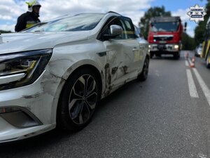 na zdjęciu uszkodzony pojazd na drodze, za nim wóz strażacki