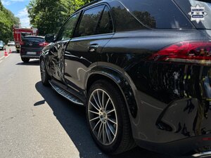 na zdjęciu uszkodzony pojazd na drodze, przed nim wóz strażacki