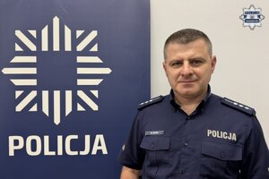 na zdjęciu policjant przy banerze z napisem policja