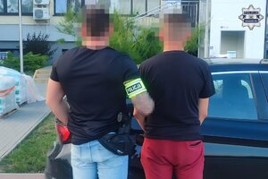 na zdjęciu policjant z zatrzymanym mężczyzną przy samochodzie
